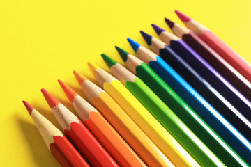Colorful pencils on yellow background