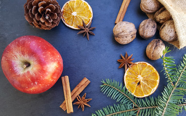 Fototapeta premium Apple ,dried orange slices, cinnamon sticks, walnuts and Christmas tree
