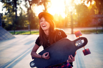 Cute urban girl holding skateboard in skatepark - hipster style photo © lordn