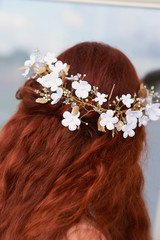 Naklejka premium Beautiful red-haired girl with long curly hair in the bride, in a long lace dress. A natural beauty.