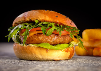 Fresh juicy delicious homemade burger. Hamburger with meat and fresh herbs.