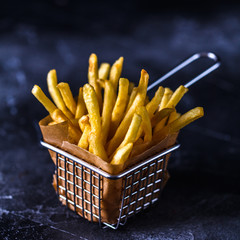 French fries in a basket on a black background
