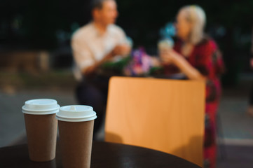 Happy elderly couple in love drinking lemonade in a cafe on the street