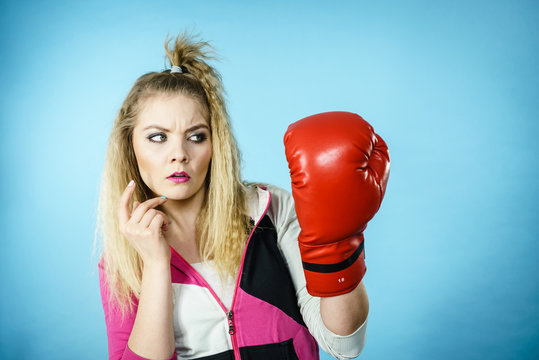 Funny confused woman wearing boxing glove