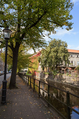 Fototapeta na wymiar View of an idyllic sidewalk and canal on a sunny day in Gdansk, Poland, at autumn.