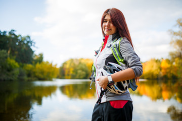 Picture of smiling woman with backpack and bicycle helmet