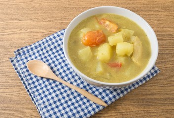 Bowl of Curry Soup with Potato and Tomato