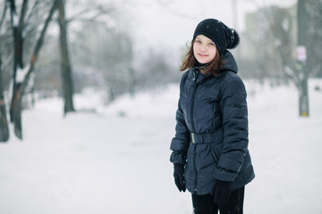 Teen girl froze. The child warms, hands clasped to his face. Portrait of a beautiful girl.