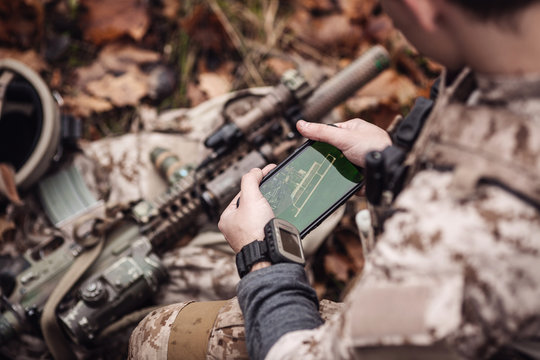 soldiers holding gps in hand and determines the location of coordinates.