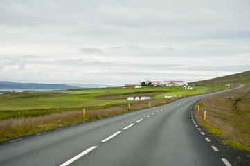Road in a typical Icelandic landscape, a wild nature of rocks and shrubs, rivers and lakes.