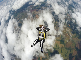 Fototapeta na wymiar Woman costumed skeleton in free fall. Skydiving Happy Halloween.