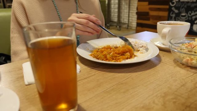 woman eating meatballs with braised cabbage in a ceramic plate. in the cafe. 4k