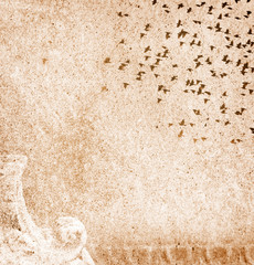 Background page design for a photo book, scrapbook or wallpaper in light marigold brown; abstract stone texture with silhouette of flying flock of birds
