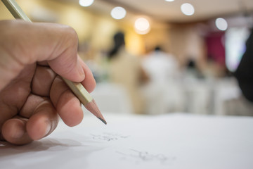Business people making and writing notes at conference seminar with blur light business peple background.Seminar is form of academic instruction, offered by a commercial or professional organizatio