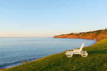 White chairs by shore of Gulf of Saint Lawrence