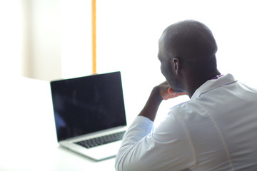 Young african doctor working on laptop at desk. Doctor. Workplace