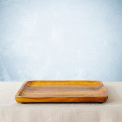 Empty squre wooden tray on sack tablecloth background, banner, food display montage, food background