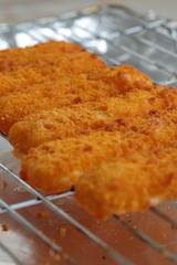 Breaded fish fingers on a grill