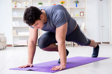 Young man exercising at home in sports and healthy lifestyle con