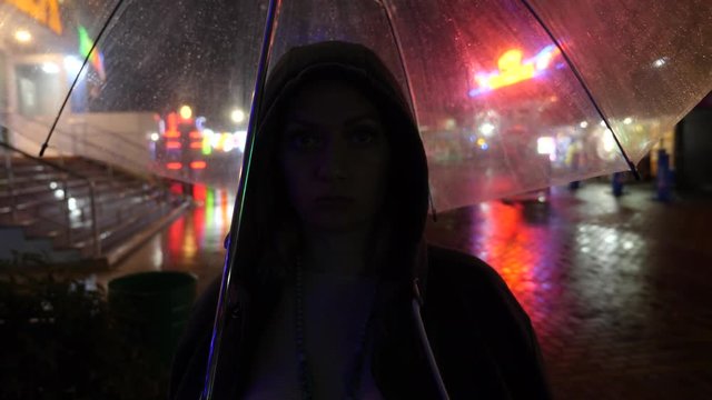 Silhouette of a man in a hood standing on a night street. 4k