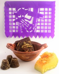Mexican traditional pumpkin sweet made with piloncillo and cinammon on a clay pot, known as calabaza en tacha with ornamental papel picado