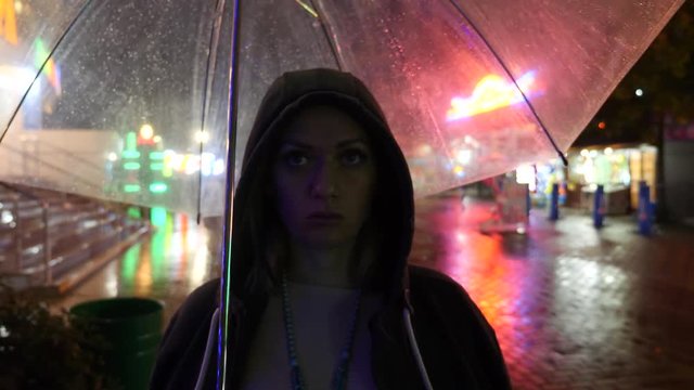 Silhouette of a man in a hood standing on a night street. 4k