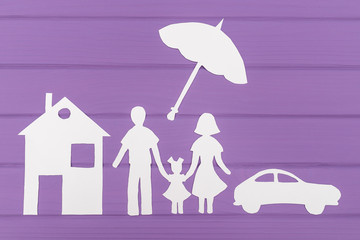 Obraz na płótnie Canvas The silhouettes cut out of paper of man and woman with one girl under the umbrella, house and car near