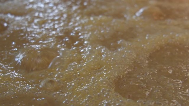 Close Up of Bourbon Mash Bubbles in Fermenting Tank