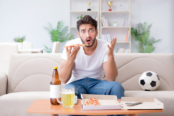 Man eating pizza having a takeaway at home relaxing resting