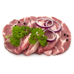 Raw pork neck chop meat with parsley herb leaves, peppercorn spices and onion slices garnish isolated on white background cutout