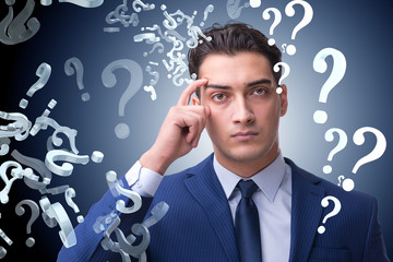 Businessman in uncertainty concept with many unanswered question