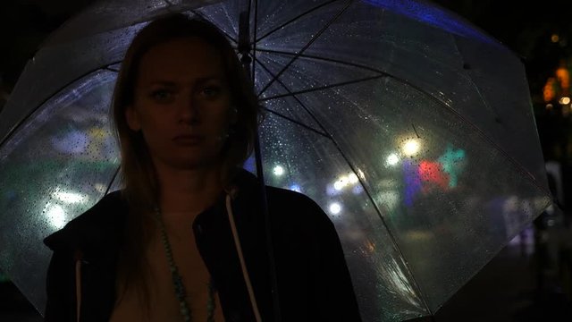 Silhouette of a man in a hood standing on a night street. 4k