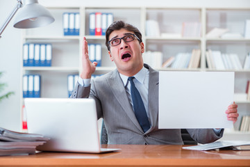 Businessman  in office holding a blank message board