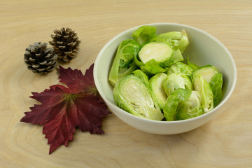 Brussel sprouts in white bowl tossed in olive oil in preparation for grilling or roasting 