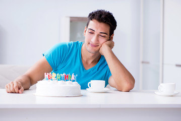 Young man celebrating birthday alone at home