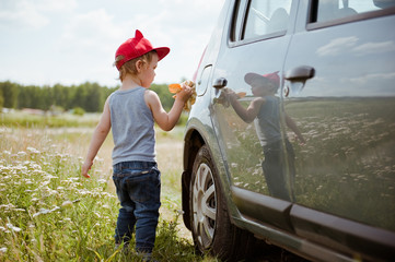 Little boy washing car