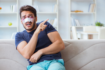 Young man recovering healing at home after plastic surgery nose 