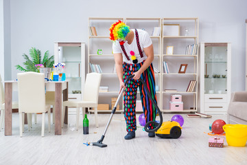 Funny clown doing cleaning at home