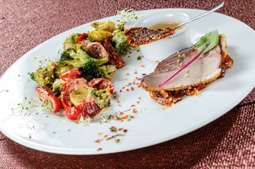 Slised meat meal with vegetables on white plate