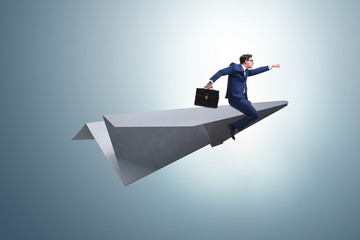 Businessman flying on paper plane in business concept