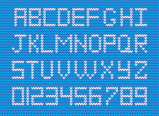White knitted alphabet and numerals on blue knitted background. Vector knitted symbols and numbers for design.