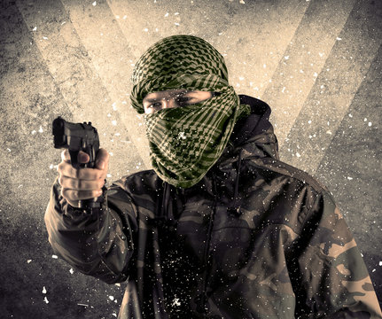 Portrait of a dangerous masked armed soldier with grungy background