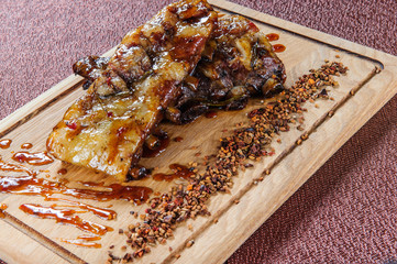 Grilled pork meat steak on wooden cutting plate over wooden table.European food.