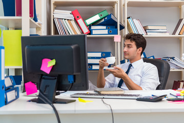 Businessman working in the office with piles of books and papers