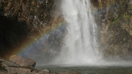 Fototapeta na wymiar Cascata con arcobaleno