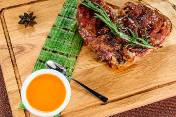Grilled pork meat steak on wooden cutting plate over wooden table.European food.