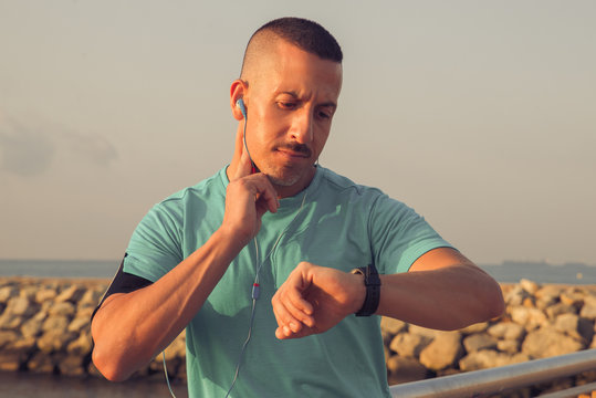 Concentrated athlete checking pulse after jogging