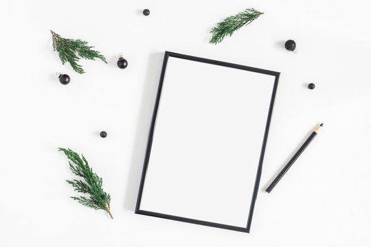 Christmas composition. Black frame and christmas tree branches on white background. Flat lay, top view, copy space