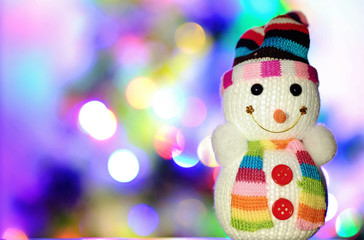 Toy snowman and Christmas lights in the background