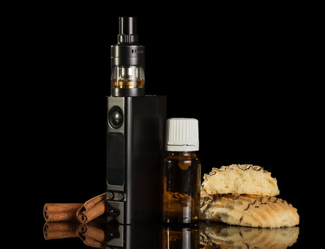 A smoking device, liquid with vanilla flavor and biscuits, isolated on black background
